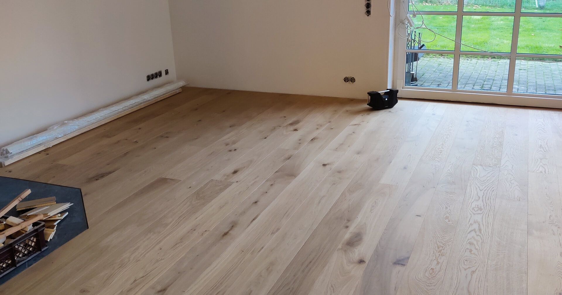 Neu verlegter Eichenparkettboden im Wohnzimmer mit Terrassentür